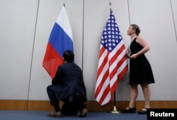 FILE - Staffers install U.S. and Russian flags as part of a bilateral meeting, Aug. 26, 2016. Theoretically, U.S. President Donald Trump and Russian President Vladimir Putin would have an opportunity to meet Friday in Vietnam but it's not clear whether substantive talks will be scheduled.