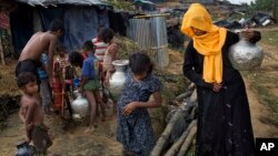 Rohingya Muslims collect water from a tube well that was installed a few days ago at new refugee camp at Cox's Bazar Ukhia area, Bangladesh, Sept. 9, 2017.