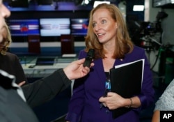 FILE - Democratic candidate for Colorado's 6th Congressional District seat, Morgan Carroll, talks with reporters after debating her opponent, incumbent U.S. Rep. Mike Coffman, at a Spanish language television station in Denver, Oct. 4, 2016.