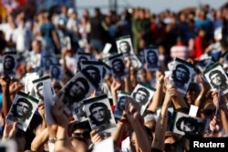 People hold images of late Cuban revolutionary hero Ernesto "Che" Guevara during a ceremony commemorating the 50th anniversary of his death, Santa Clara, Cuba, Oct. 8, 2017.