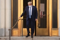 U.S. President Donald Trump walks out the front doors and down the front steps of Walter Reed National Military Medical Center after a fourth day of treatment for the coronavirus disease (COVID-19) while returning to the White House in Washington.
