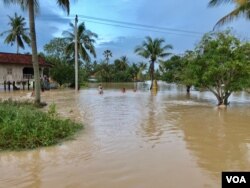 ទឹកហូរ​ចូល​ផ្ទះមួយខ្នង​របស់អ្នកភូមិ​ ក្រោយការ​បាក់​ទំនប់​អាងទឹក​មួយ​ក្នុង​ស្រុក​ទឹក​ឈូ​ ខេត្ត​កំពត​ ថ្ងៃទី​១១ ខែ​សីហា​ ឆ្នាំ​ ២០១៩​។ (ហ៊ុល រស្មី​/VOA)
