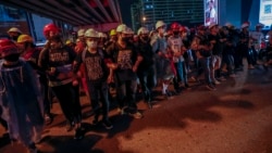 Pro-democracy activists create a human chain to confront a police barricades during their march to the Government House, prime minister's office during a protest march in Bangkok, Thailand, Wednesday, Oct. 21, 2020. (AP Photo/Sakchai Lalit)