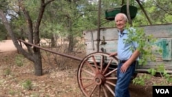 Forrest Fenn stands in front of an original 19th century cart he had placed on the old Santa Fe trail running through his property. (VOA/Penelope Poulou)