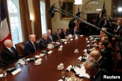 U.S. President Donald Trump speaks as he hosts an expanded bilateral meeting in the Cabinet Room with French President Emmanuel Macron (R, 3rd from bottom) and other officials following the official arrival ceremony for Macron at the White House in Washin