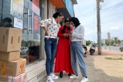 In this June 5, 2019, photo, women from the the Hui Muslim ethnic minority from a nearby neighborhood gather outside a shop near an OFILM factory in Nanchang in eastern China's Jiangxi province. (AP Photo/Ng Han Guan)