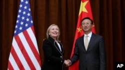 U.S. Secretary of State Hillary Rodham Clinton, left, and Chinese Foreign Minister Yang Jiechi, right, shake hands during her visit to Beijing, Sept. 4, 2012.