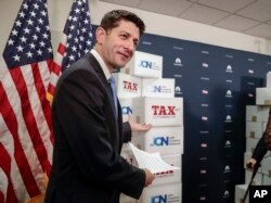 Speaker of the House Paul Ryan, R-Wis., points to boxes of petitions supporting the Republican tax reform bill that is set for a vote later this week as he arrives for a news conference on Capitol Hill in Washington, Nov. 14, 2017.