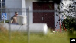 FILE - Bullet holes were marked by police at the front of the building as law enforcement officials continue to investigate the scene of a shooting at the First Baptist Church of Sutherland Springs in Sutherland Springs, Texas, Nov. 7, 2017.