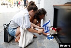Israelis light candles near the site of a Palestinian shooting attack in Tel Aviv, June 9, 2016.