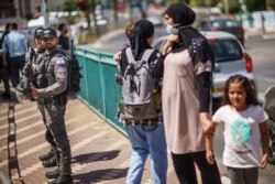 Police stand by during a demonstration calling for justice in the killing of Musa Hassuna in the mixed Arab-Jewish town of Lod, central Israel, Friday, May 28, 2021. (AP Photo/David Goldman)