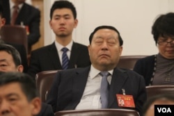 A delegate at Chinese People's Political Consultative Conference takingb a nap.