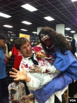 Seorang pria memegang boneka zombie di konvensi Walker Stalker di Atlanta, Georgia. (VOA/Marissa Melton)