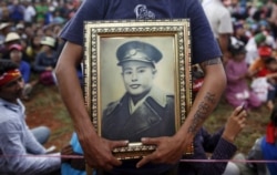 Seorang pria memegang potret Jenderal Aung San, ayah dari pemimpin pro-demokrasi Myanmar Aung San Suu Kyi, selama pidatonya tentang pendidikan pemilih di kotapraja Hsiseng di negara bagian Shan, Myanmar, 5 September 2015. (Foto: REUTERS/Soe Zeya Tun )