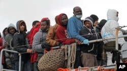 Migrants waits to leave a tugboat after being rescued in Porto Empedocle, Sicily earlier this year.