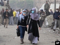 Misr inqilobida ayollar faol ishtirok etdi. Suratda Qohira ko'chalarida namoyishchilarga qarata otilgan ko'zdan yosh chiqaruvchi gazdan o'zini himoyalash maqsadida yuziga niqob taqib olgan ikki misrlik ayol aks etgan. 6-fevral, 2012-yil.