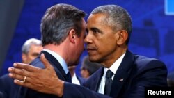 U.S. President Barack Obama embraces British Prime Minister David Cameron during a NATO Summit in Warsaw, Poland, July 8, 2016.