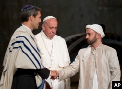 Pope Francis looks at Imam Khalid Latif, right, and Rabbi Elliot J. Cosgrove, left, shaking hands as he arrives for an interfaith service at the Sept. 11 memorial museum in New York, Sept. 25, 2015.