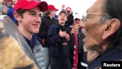 켄터키주 코빙턴 가톨릭고등학교 2학년생인 닉 샌드먼과 인권 활동가이자 베트남전 참전용사인 네이선 필립스 씨가 지난 18일 워싱턴 링컨기념관 앞에서 서로를 마주보고 있다. 사진제공=Kaya Taitano/Social Media