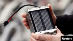 An employee holds an hydrogen fuel battery of an Alpha bike, first industrialized bicycle to use a hydrogen fuel cell at the Pragma Industries factory in Biarritz, France, Jan. 15, 2018.