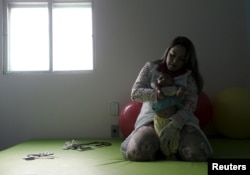 Physiotherapist Jeime Lara Leal does exercises with Lucas, 4 months old, who is Miriam Araujo's second child and born with microcephaly in Pedro I hospital in Campina Grande, Brazil, Feb. 17, 2016.