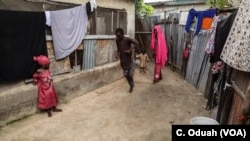 Kids play a game of egalagala in front of their home.