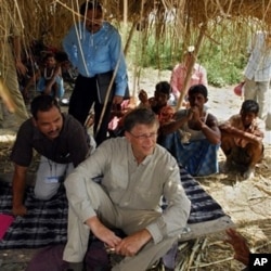FILE - Microsoft co-founder Bill Gates, center, speaks with a villager in Aulali, Khagaria district, before heading to Guleria, in Bihar state, Wednesday, May 12, 2010.