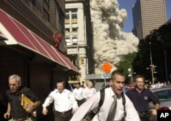 ហ្វូង​មនុស្ស​រត់ចេញ​ពី​មជ្ឈមណ្ឌល​ពាណិជ្ជកម្ម​ពិភពលោក​ដែល​រំលំដួល​ក្នុង​រដ្ឋធានីញូយ៉ក កាលពីថ្ងៃទី១១ កញ្ញា ២០០១។