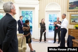 FILE - President Barack Obama talks with national security staff in the Oval Office after being notified of the nuclear agreement with Iran, July 13, 2015.