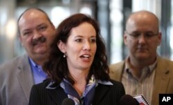 FILE - Lambda Legal attorney Camilla Taylor, center, talks to reporters with plaintiffs Glenn Funhouser, left, and his partner Henry Greene, from Indianapolis, Ind., after attending a hearing before the 7th U.S. Circuit Court of Appeals on the challenges to Indiana and Wisconsin's gay marriage ban, Aug. 26, 2014, in Chicago.