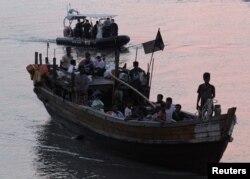FILE - Rohingya refugees, who were intercepted by Malaysian Maritime Enforcement Agency off Langkawi island, are escorted in their boat as they are handed over to immigration authorities, at the Kuala Kedah ferry jetty in Malaysia, April 3, 2018.