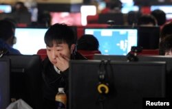 FILE - A slew of people use computers at an internet cafe in Hefei, Anhui province, March 16, 2012.
