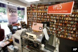 Seorang pengunjung sebang membaca buku di toko buku Politics and Prose di Washington, 5 Juni 2012.