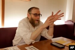 Daniel Cohen, owner of Pinskers Books and Judaica, and the adjoining cafe, sits at a table before dinner service, Nov. 20, 2018, in the Squirrel Hill neighborhood of Pittsburgh.