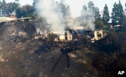 A multimillion-dollar home is a smoldering ruin after a wildfire swept through the Bel Air district of Los Angeles, Dec. 6, 2017.
