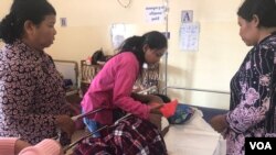 ក្រុមគ្រួសារ មានម្តាយ និងបងស្រី មើលថែលោក ពៅ សារ័ត្ន ដែលរងរបួសដោយសារគ្រាប់កាំភ្លើងរបស់សមត្ថកិច្ច ក្នុងរឿងជម្លោះដីធ្លី (ស៊ុន ណារិន/VOA)