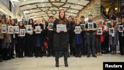 People hold portraits and printed names of victims of the Tu-154 plane, which crashed into the Black Sea on its way to Syria on Sunday, during a memorial event in Rostov-On-Don, Russia, Dec. 26, 2016.
