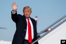 FILE - President Donald Trump waves as he boards Air Force One, Jan. 18, 2018, at Andrews Air Force Base, Md.