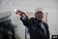 Kenyan opposition politician Miguna Miguna, who also holds Canadian citizenship and travels on a Canadian passport, reacts after Kenyan immigration authorities denied him entry into the country without a Kenyan visa, at Jomo Kenyatta International Airport.
