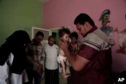Staff weigh Galila, a 9-month old Yemeni girl who suffers from malnutrition and malaria, at the Stabilization Nutritional Therapeutic center in al-Khoukha, Yemen, Feb. 12, 2018.
