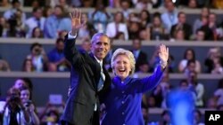 President Barack Obama and Democratic Presidential candidate Hillary Clinton wave together during the third day of the Democratic National Convention in Philadelphia , July 27, 2016.