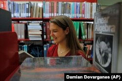 In this photo taken July 26, 2010, Brittany Wolfe, a University of California Los Angeles Applied Mathematics 2010 graduate, checks old text books at the UCLA Powell Library Building, in Los Angeles.