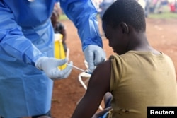 FILE - A Congolese health worker administers Ebola vaccine to a boy who had contact with an Ebola sufferer in the village of Mangina in North Kivu province of the Democratic Republic of the Congo, Aug. 18, 2018.