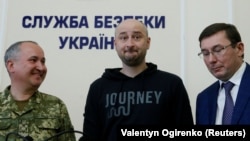 UKRAINE - Russian journalist Arkady Babchenko (C), who was reported murdered in the Ukrainian capital on May 29, Ukrainian Prosecutor General Yuriy Lutsenko (R) and head of the state security service (SBU) Vasily Gritsak attend a news briefing in Kyiv, Uk