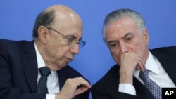 Brazil's acting President Michel Temer, right, talks with his Economy Minister Herinque Meirelles.
