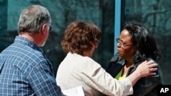 ავრორას კონოთეატრში მოკლული ადამიანების ოჯახის წევრები ერთმანეთს უსამძიმრებენ.