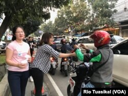 Mahasiswa Universitas Kristen Maranatha membagikan takjil, Jumat (17/5/2019), dalam acara kerjasama PKKP Maranatha dan 30 organisasi lintas-iman di kota Bandung. (Foto: VOA/Rio Tuasikal)