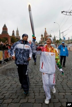The great Russian artistic gymnast Svetlana Khorkina holds a torch during a relay for the Sochi Winter Olympic Games in Moscow, Russia, Oct. 7, 2013.