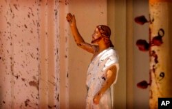 Blood stains are seen on the wall and on a Jesus Christ statue at the St. Sebastian's Church after blast in Negombo, north of Colombo, Sri Lanka, Sunday, April 21, 2019.