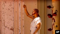 Blood stains are seen on the wall and on a Jesus Christ statue at the St. Sebastian's Church after blast in Negombo, north of Colombo, Sri Lanka, Sunday, April 21, 2019.